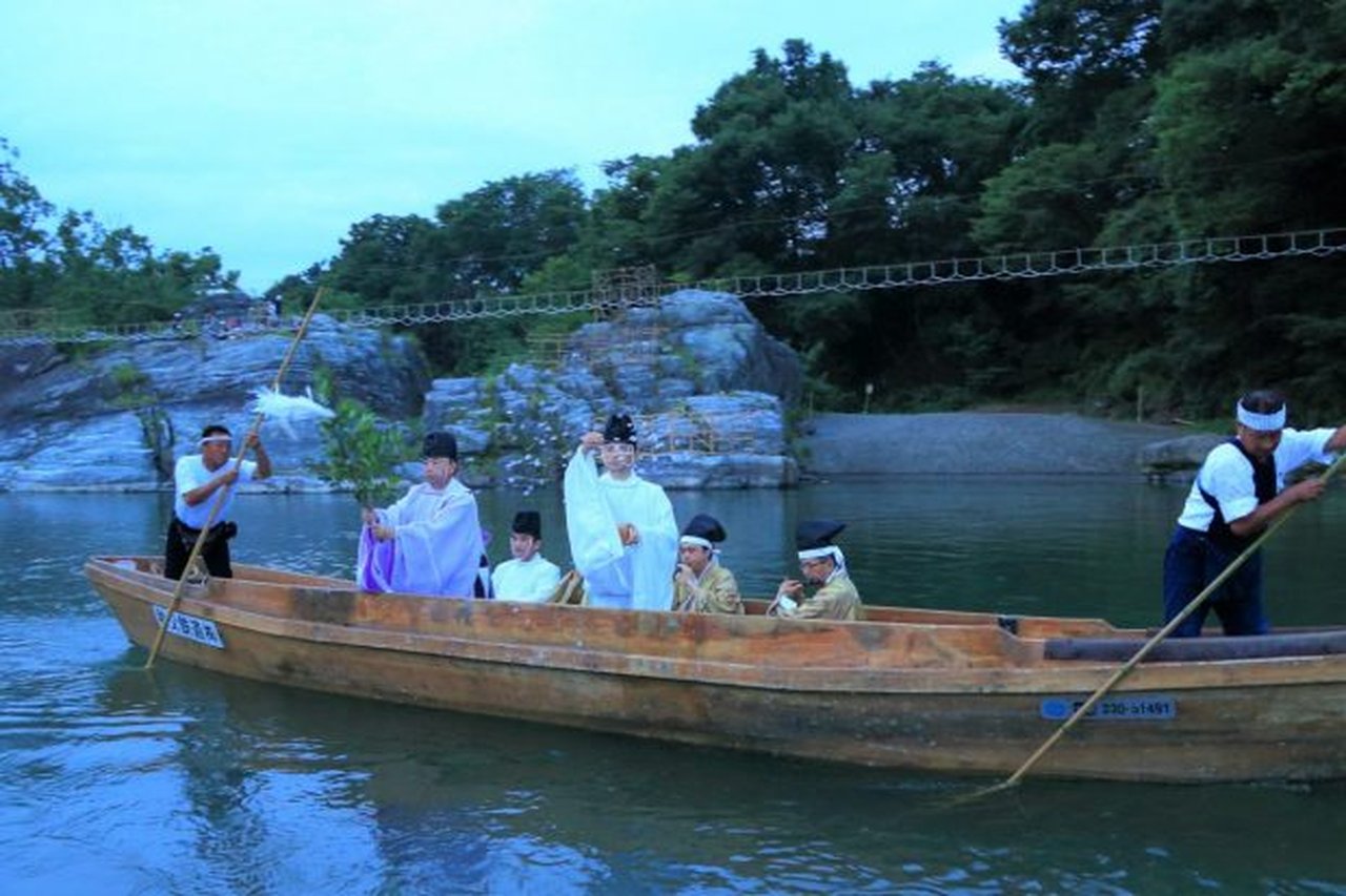 長瀞船玉まつりで、神職と関係者が儀式のために船で川を進む伝統的な光景
