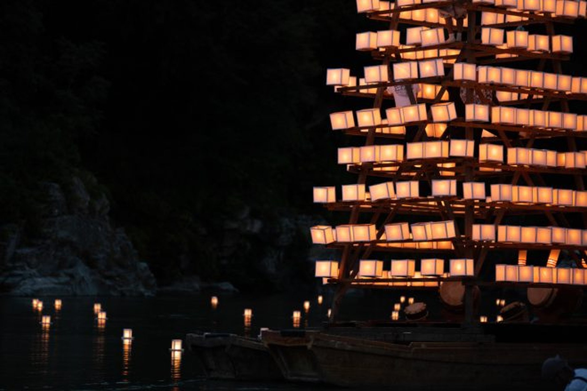 夜の長瀞船玉まつりで、川面に灯りが反射する幻想的な灯籠船の横姿