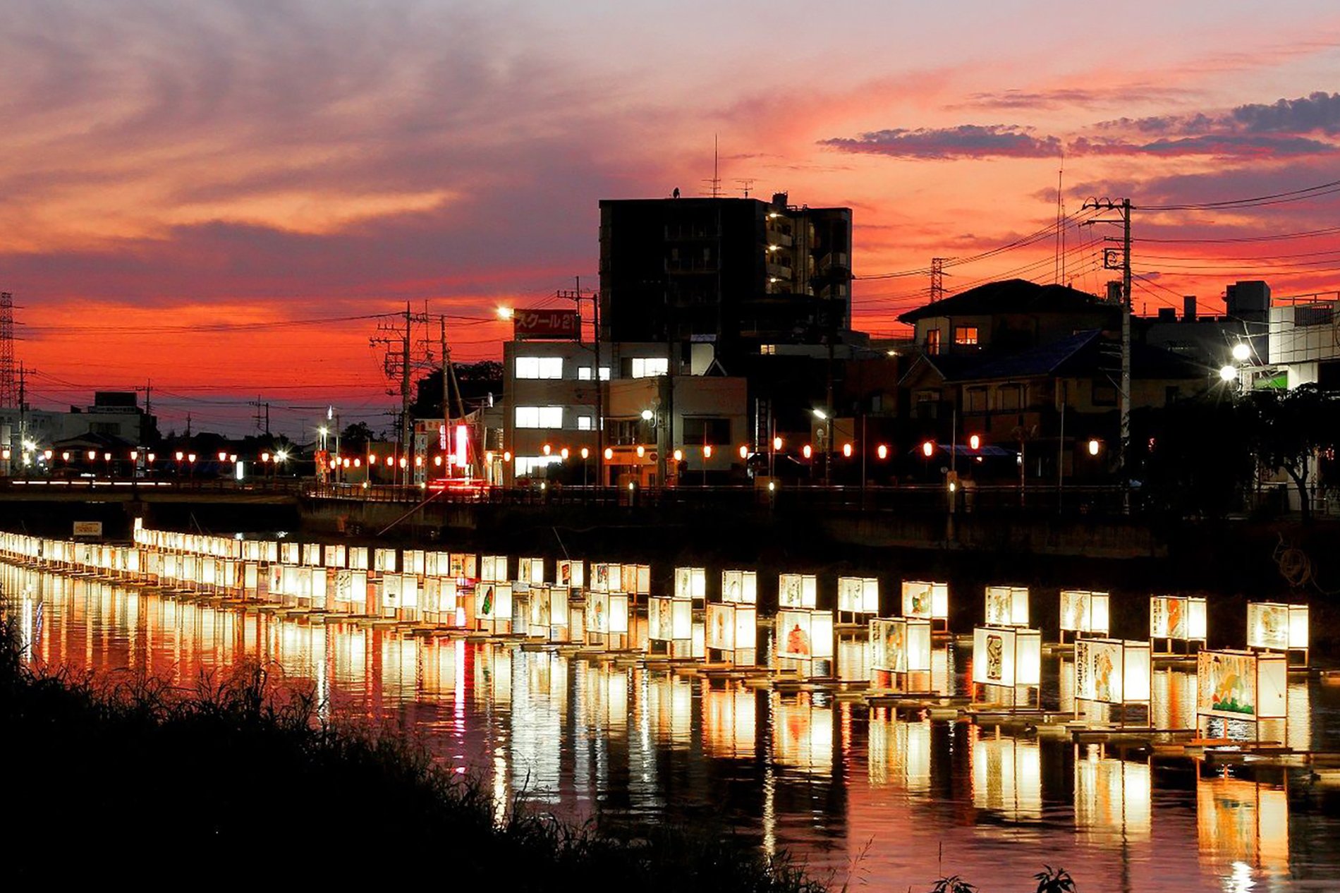 夕焼けの古利根川に灯籠が並ぶ流灯まつりの風景