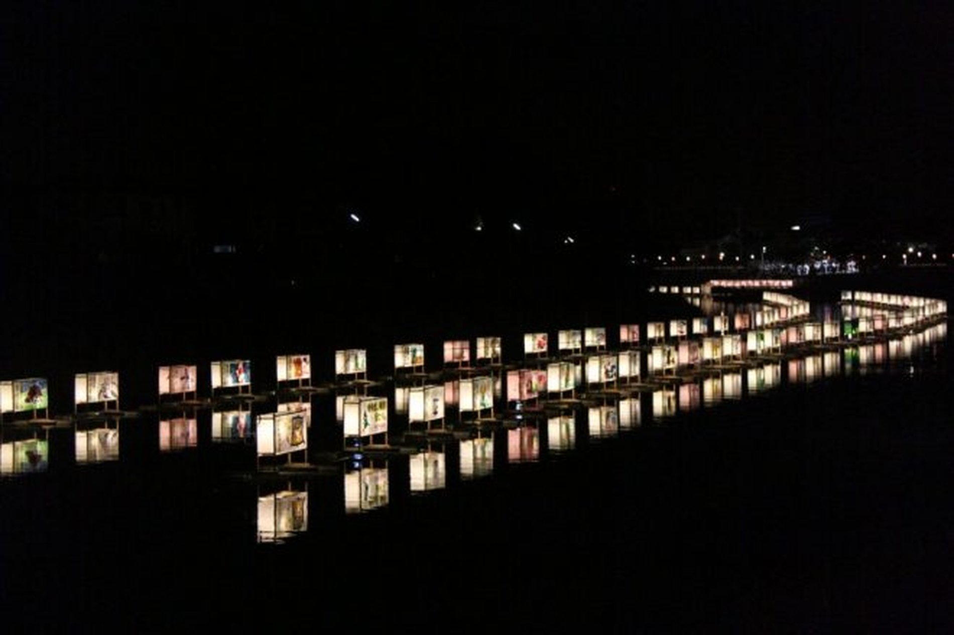 夜の古利根川に無数の灯籠が浮かぶ幻想的な景色