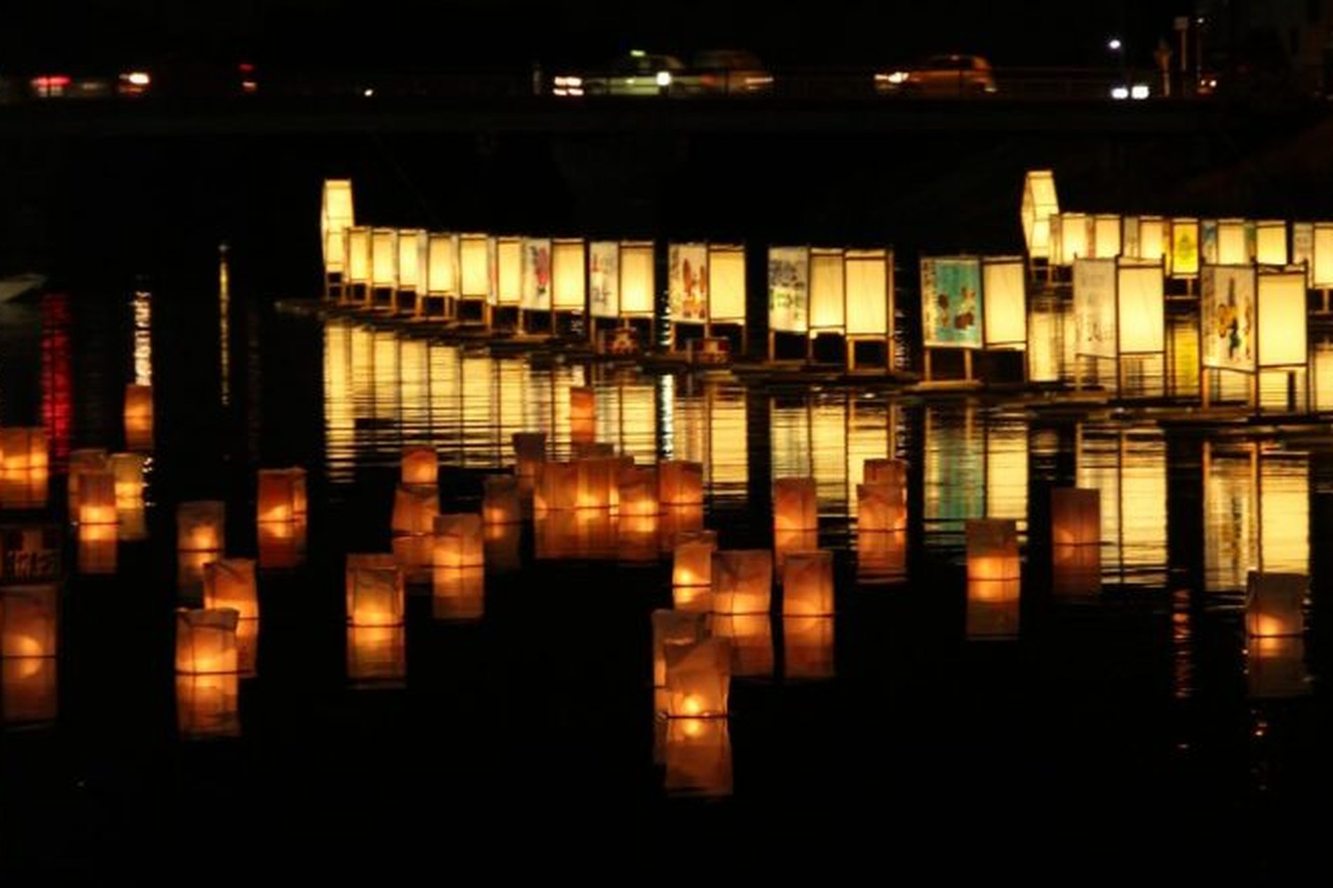 水面に揺れる灯籠が夜の古利根川を照らす様子