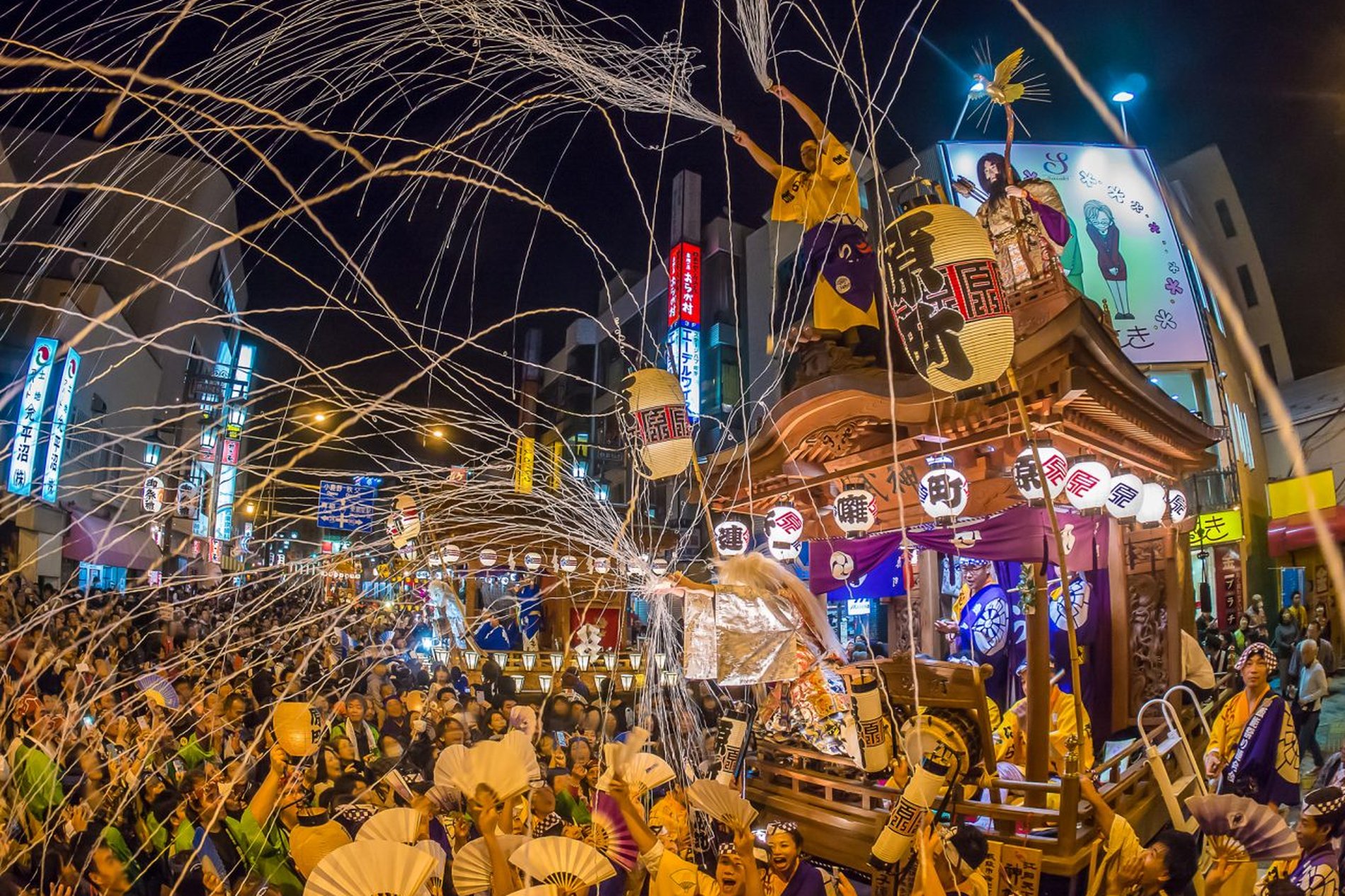 紙テープに包まれた山車が進み観客が盛り上がる飯能まつりの様子