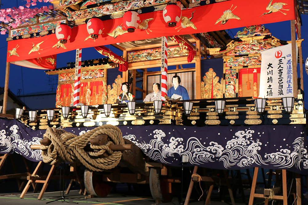 小鹿野春まつりの山車舞台で、華やかな衣装の役者が演舞を披露する様子