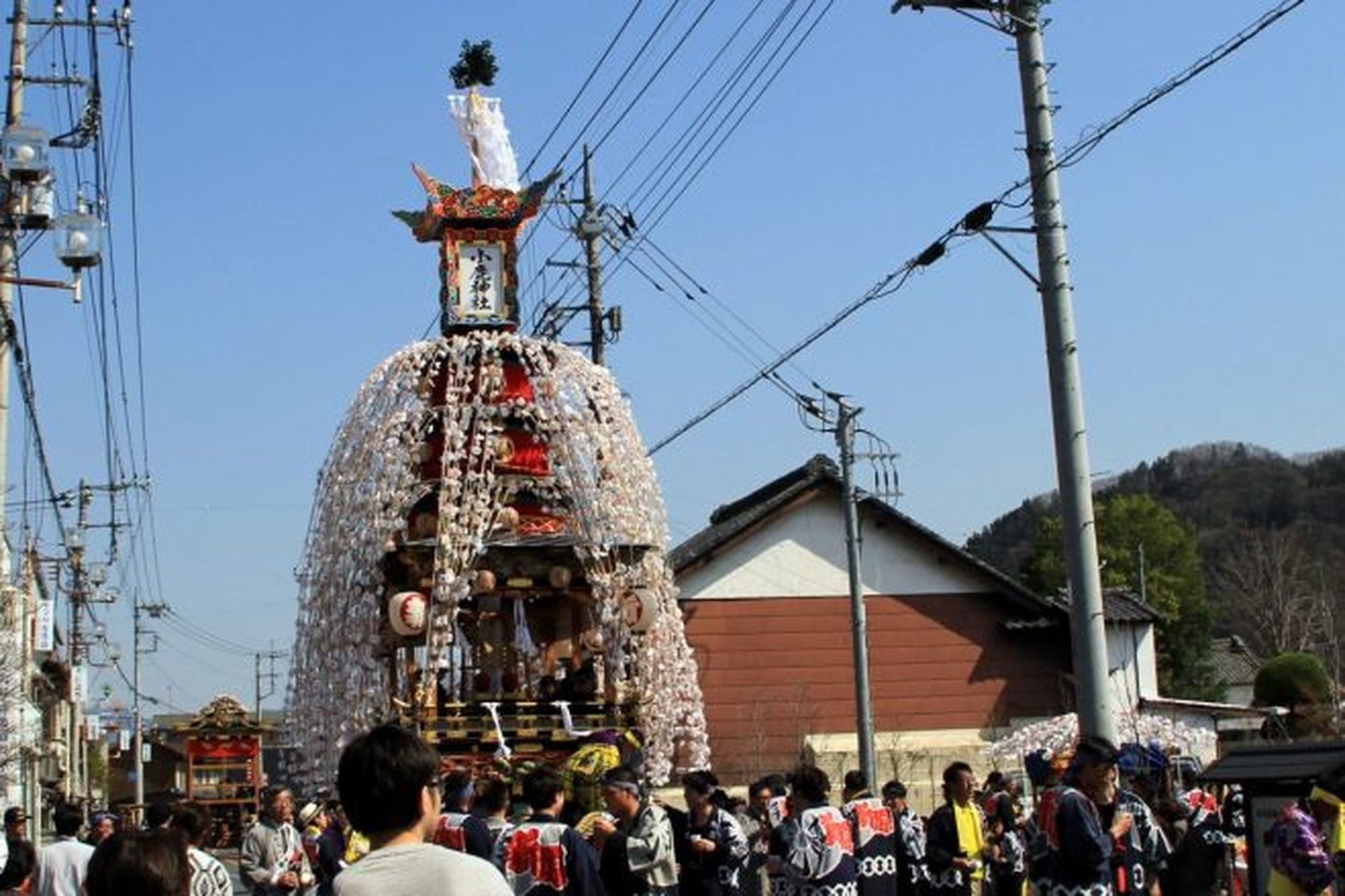 白い紙花で覆われた山車が町を進む小鹿野春まつりの昼間の様子