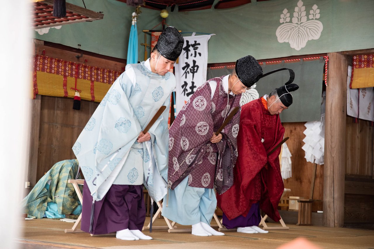 龍勢祭の神事で、神職が伝統的な装束をまとい拝礼する場面