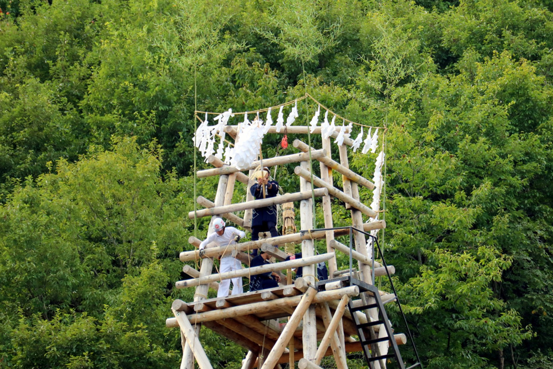 龍勢祭の発射櫓で、職人たちが龍勢の準備と点火作業を行う姿