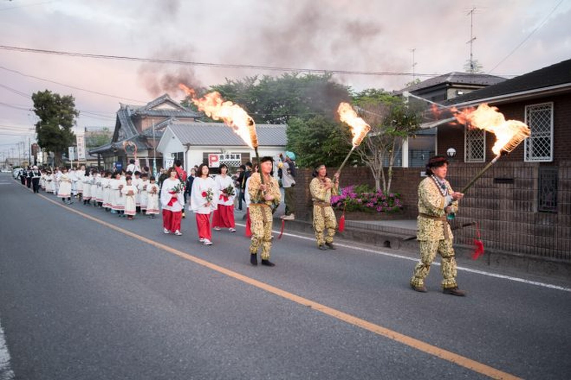 さきたま火祭りで松明を持つ一行が街中を進む行列の様子