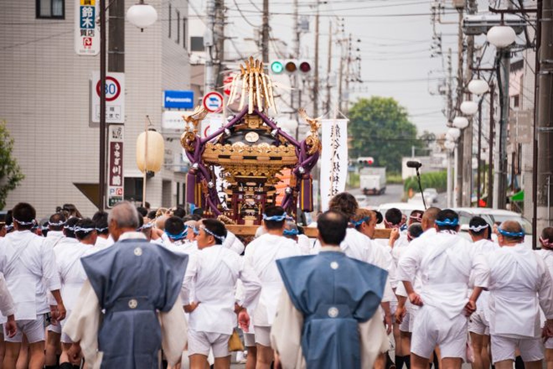 白装束の担ぎ手たちが神輿を担ぎ、市街地を練り歩く熊谷うちわ祭の神輿渡御