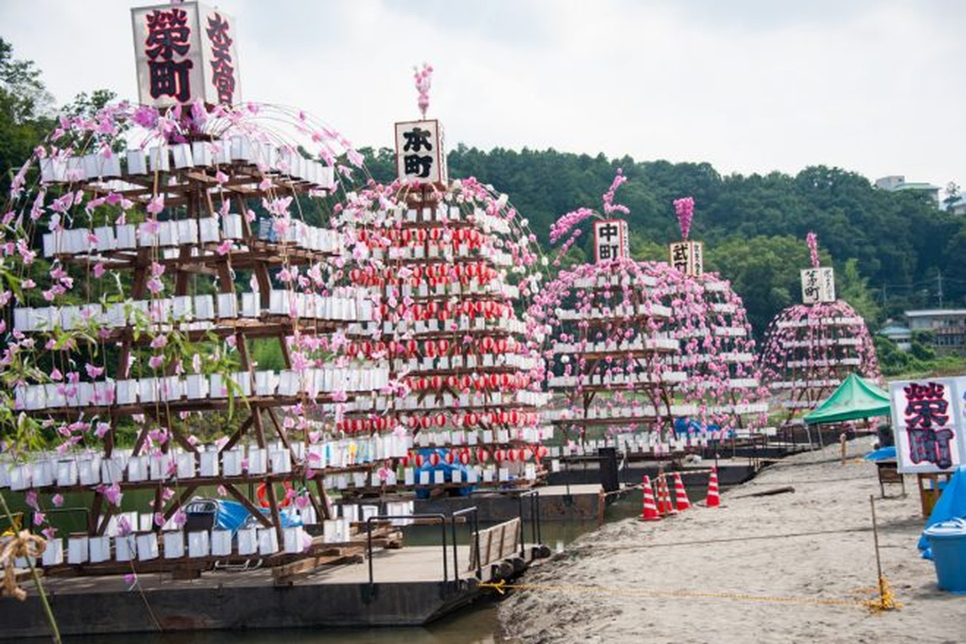 河川敷に並ぶ各町の万灯が、寄居玉淀水天宮祭の準備風景として立ち並ぶ様子